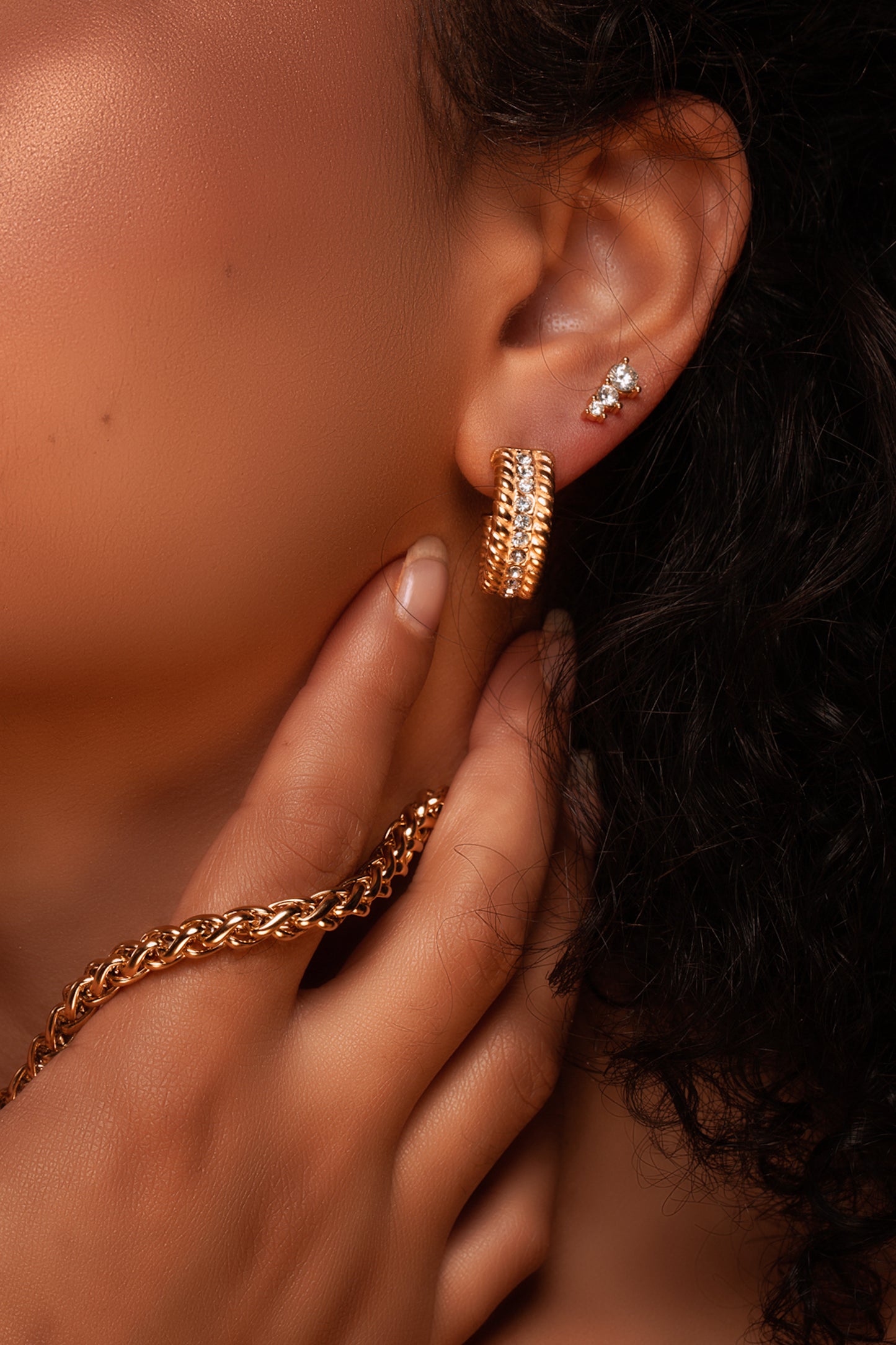Woman wearing 3 stone cubic zirconia earrings. Women's Stainless Steel Three-Stone Cubic Zirconia Gold Earrings, Hypoallergenic and Waterproof, Elegant Fashion Jewelry